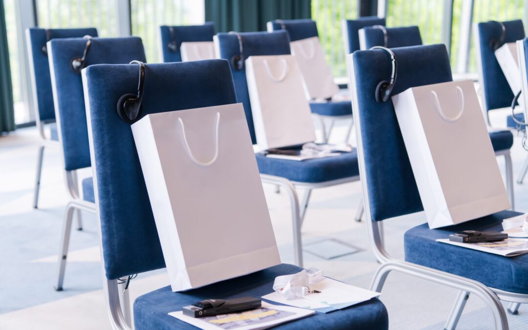Office setup featuring chairs with bags of corporate holiday gifts prepared for employees